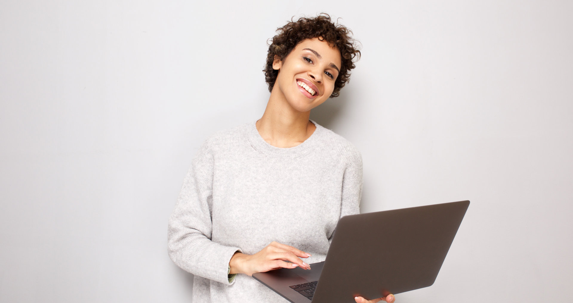 a woman smiling holding her laptop